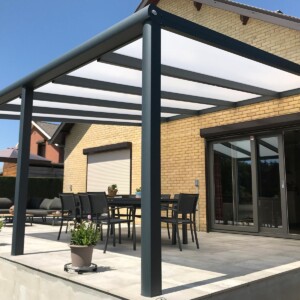 Pergola toit fixe ouverte accolée à une maison à briques jaunes